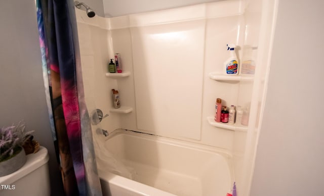 bathroom featuring shower / tub combo and toilet