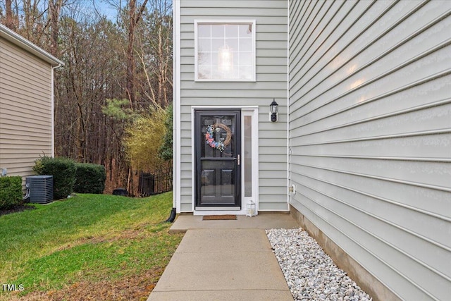 property entrance with central AC and a lawn