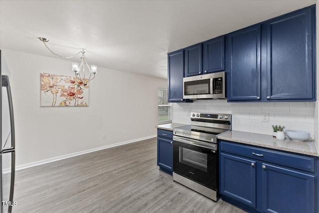 kitchen featuring light wood-type flooring, blue cabinetry, tasteful backsplash, and appliances with stainless steel finishes