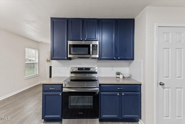 kitchen with stainless steel appliances, blue cabinetry, light wood-style floors, and decorative backsplash