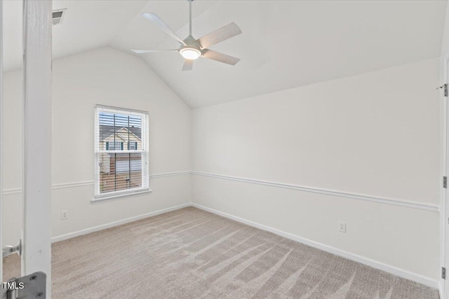 carpeted empty room featuring a ceiling fan, lofted ceiling, and baseboards