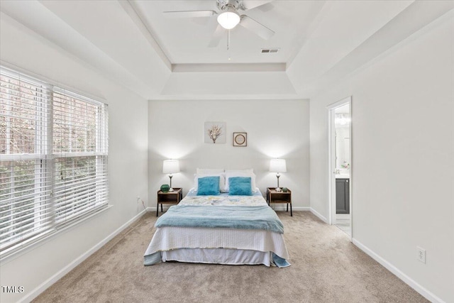 bedroom featuring carpet, a raised ceiling, visible vents, and baseboards