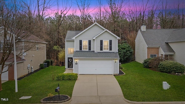 traditional home featuring a garage, driveway, a front lawn, and central air condition unit