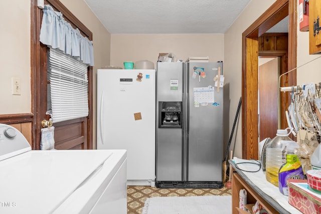 kitchen with stainless steel refrigerator with ice dispenser, a textured ceiling, washer / clothes dryer, and white fridge