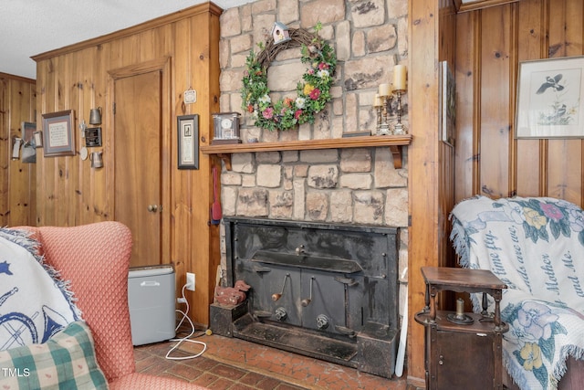 living room featuring wood walls, crown molding, and a fireplace