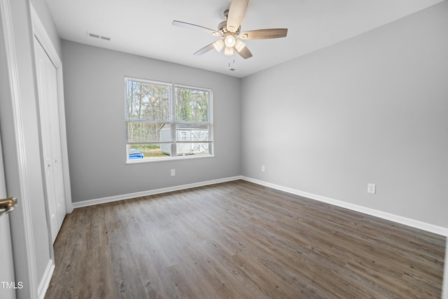 unfurnished bedroom featuring ceiling fan, a closet, and dark wood-type flooring