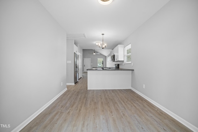 kitchen featuring white cabinetry, decorative light fixtures, light hardwood / wood-style floors, kitchen peninsula, and stainless steel appliances