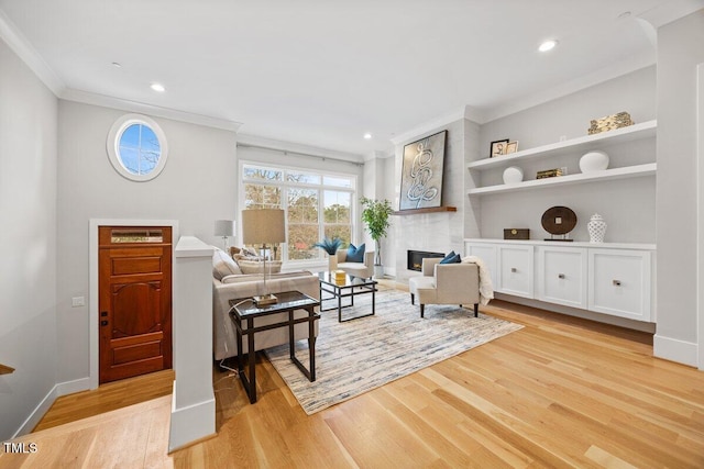 living room featuring crown molding and light hardwood / wood-style flooring