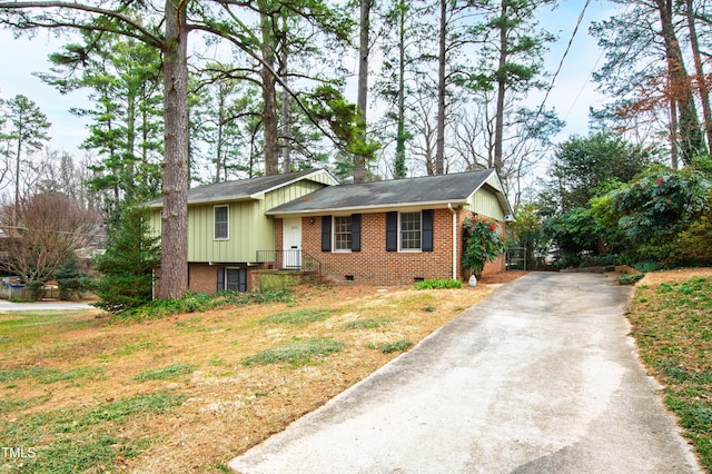 view of front facade featuring board and batten siding, crawl space, brick siding, and concrete driveway