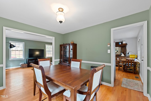 dining area with baseboards and light wood-style floors