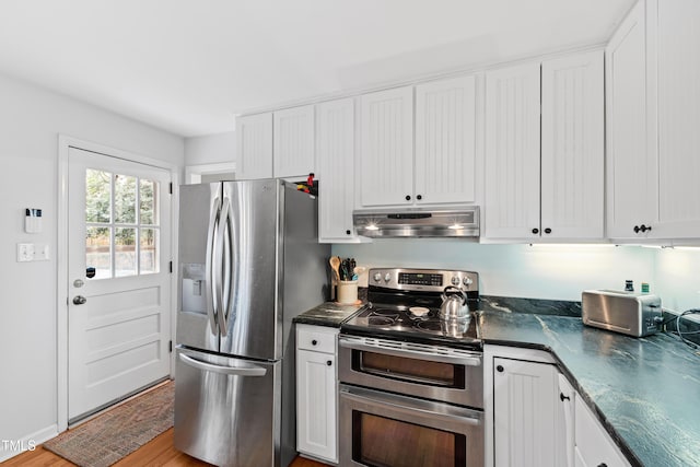 kitchen with stainless steel appliances, white cabinets, and under cabinet range hood