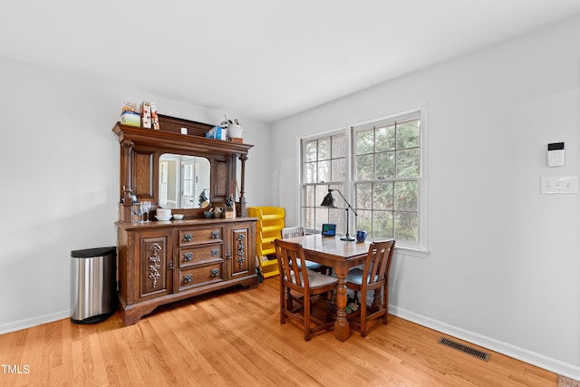 dining area featuring light wood-style floors, baseboards, and visible vents