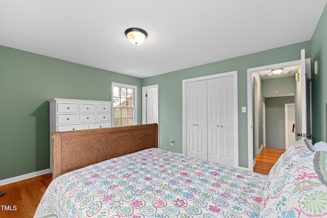 bedroom with baseboards, a closet, and wood finished floors