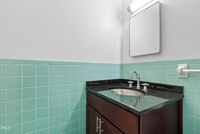 half bathroom with wainscoting, vanity, and tile walls