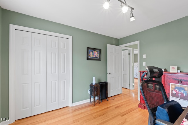 office space featuring light wood-style floors, baseboards, and track lighting