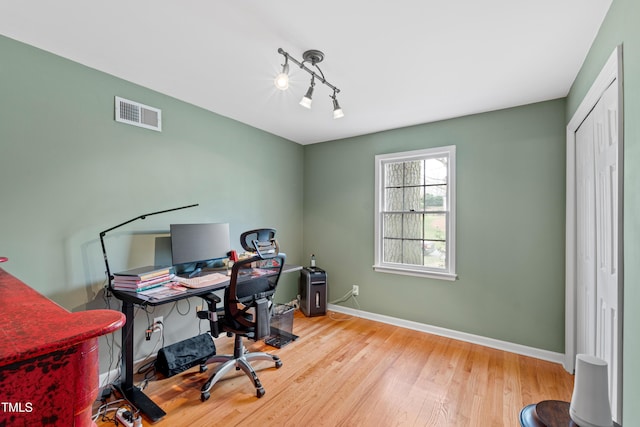 home office featuring wood finished floors, visible vents, and baseboards