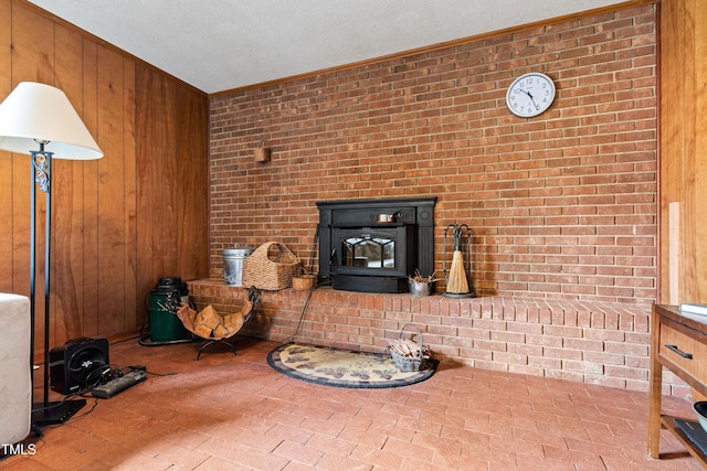 unfurnished living room featuring brick floor, a wood stove, and wood walls