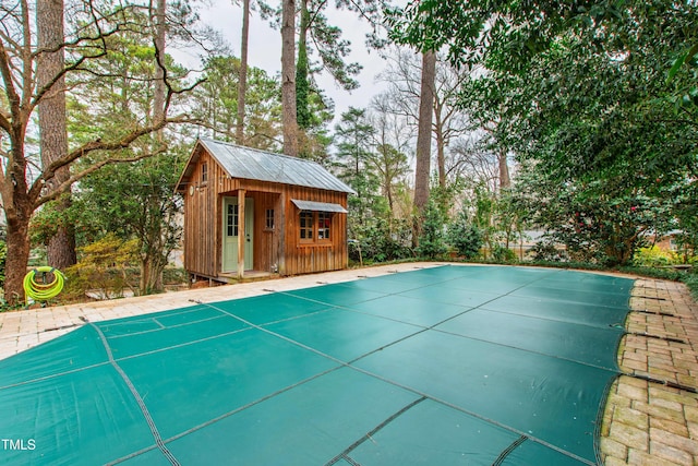 view of pool with an outbuilding