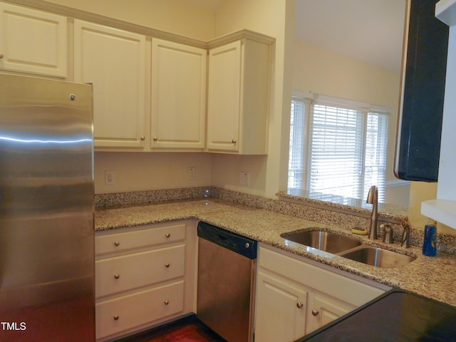 kitchen with light stone countertops, sink, and appliances with stainless steel finishes