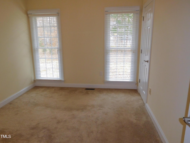 spare room featuring light colored carpet