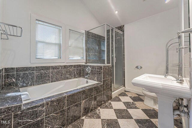 bathroom with separate shower and tub, toilet, and vaulted ceiling