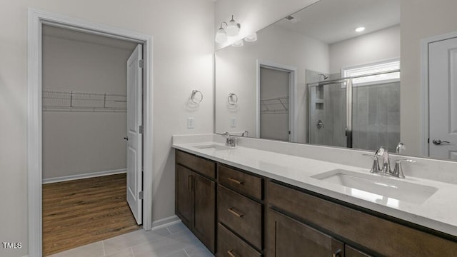 bathroom with hardwood / wood-style floors, vanity, and a shower with door