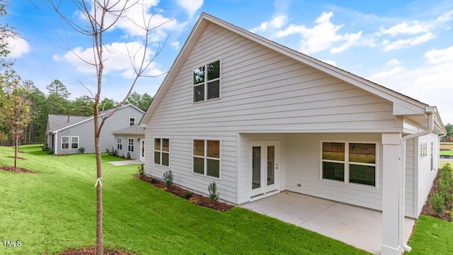 back of property with a yard and a patio