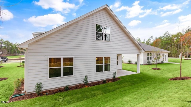 view of side of property featuring a lawn and a patio