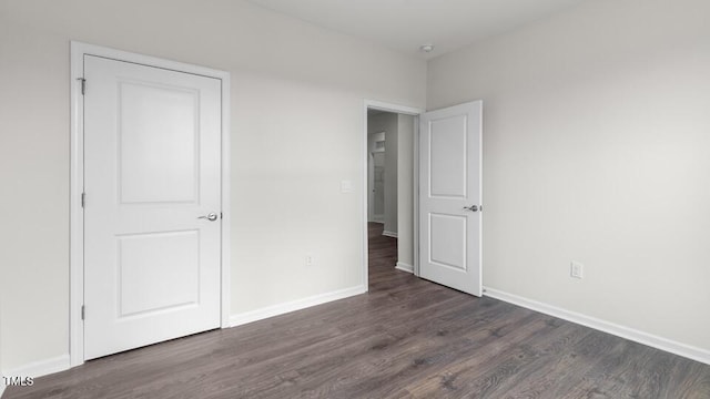 unfurnished bedroom with dark wood-type flooring