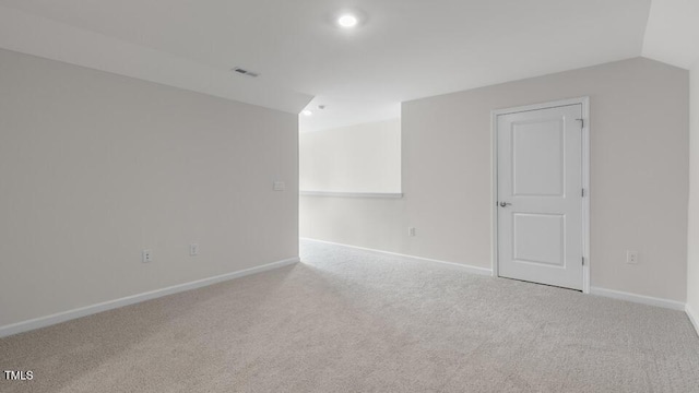 empty room featuring light carpet and lofted ceiling