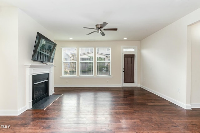 unfurnished living room featuring ceiling fan and dark hardwood / wood-style flooring