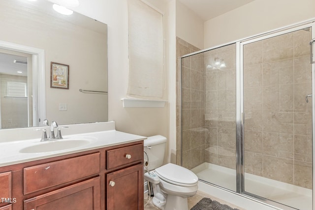 bathroom featuring vanity, a shower with shower door, and toilet