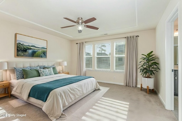 carpeted bedroom featuring a raised ceiling and ceiling fan