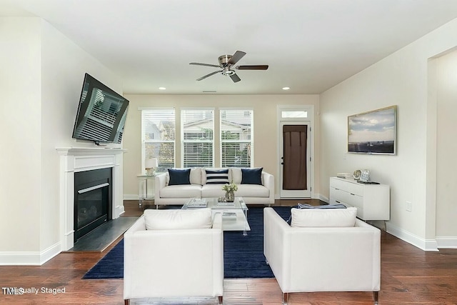 living room featuring dark wood-type flooring and ceiling fan