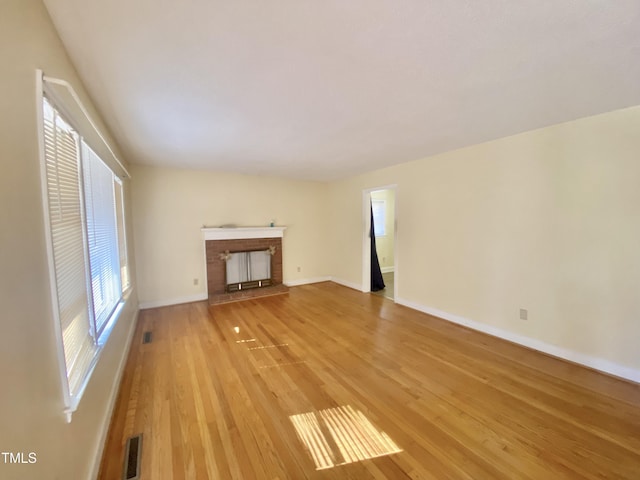 unfurnished living room with light wood-type flooring and a fireplace