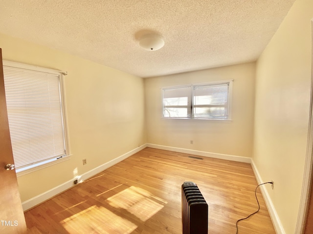 unfurnished room featuring a textured ceiling and hardwood / wood-style flooring