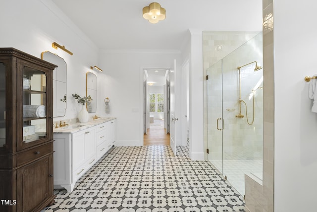 bathroom featuring vanity, a shower with door, and ornamental molding