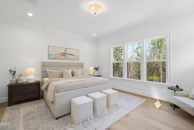 bedroom featuring light wood-type flooring and ornamental molding