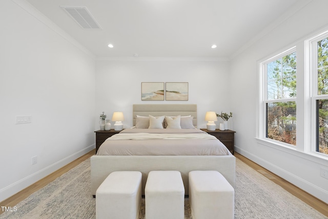 bedroom with light hardwood / wood-style flooring and crown molding