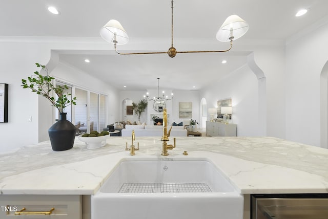 kitchen with crown molding, beverage cooler, and light stone countertops