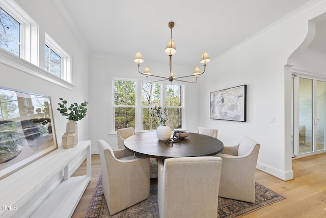 dining room featuring a chandelier, crown molding, and light hardwood / wood-style floors