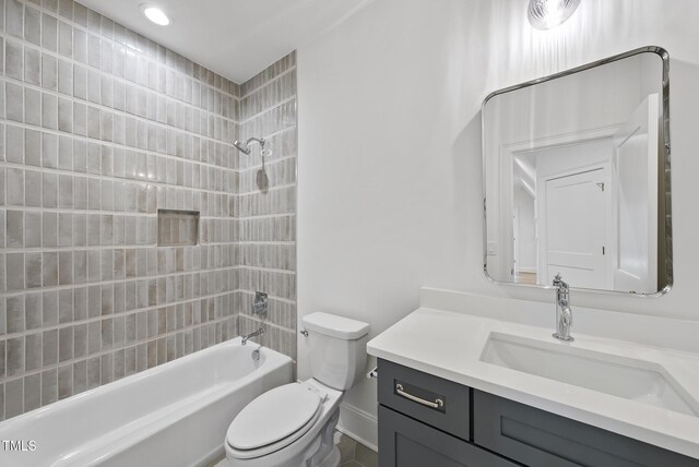 full bathroom with toilet, vanity, and tiled shower / bath