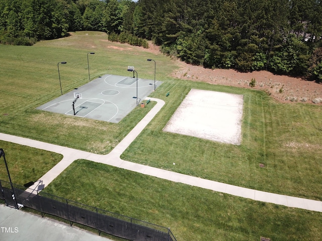 view of sport court featuring a lawn