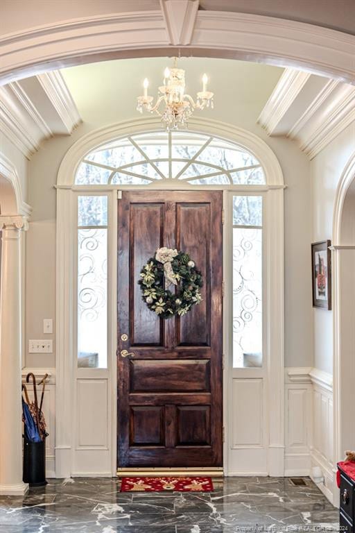 entryway featuring a healthy amount of sunlight, a notable chandelier, and ornamental molding