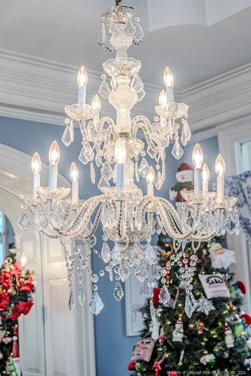 interior details featuring crown molding and a notable chandelier