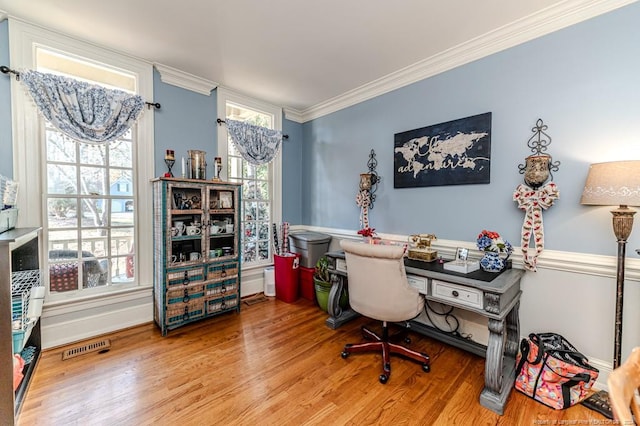 office space with hardwood / wood-style flooring, crown molding, and a healthy amount of sunlight