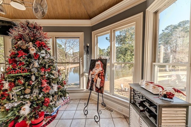 entryway with wood ceiling, a water view, light tile patterned floors, and a wealth of natural light