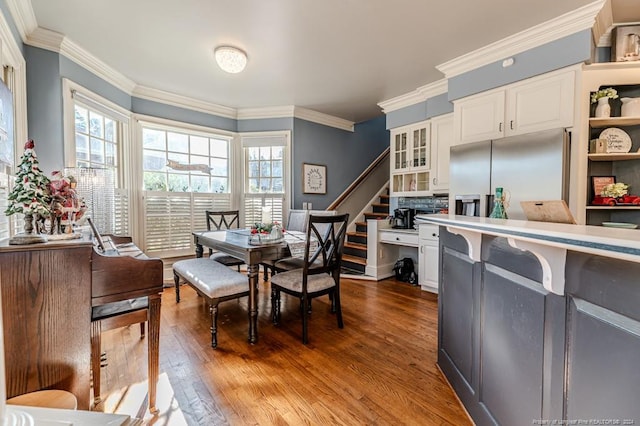 dining area with wood-type flooring and crown molding