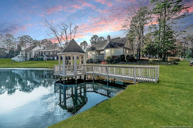 view of dock with a water view, a yard, and a gazebo