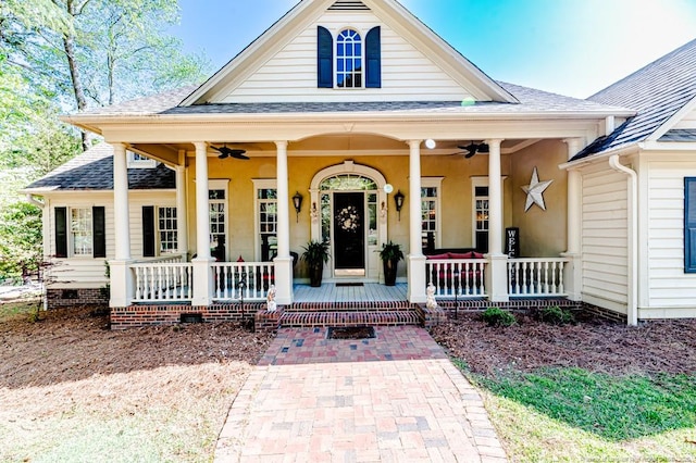 view of front facade featuring roof with shingles, covered porch, and a ceiling fan